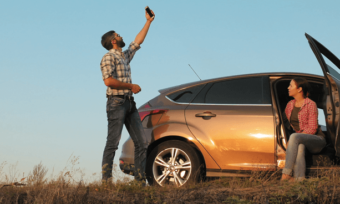 Couple searching for phone signal in mobile black spot