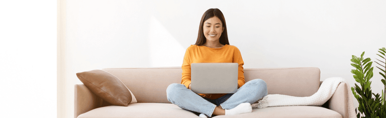 Happy woman using laptop at home