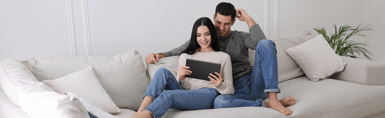 Couple using home internet on couch.