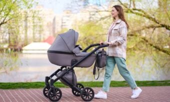 Mother pushing pram in a park