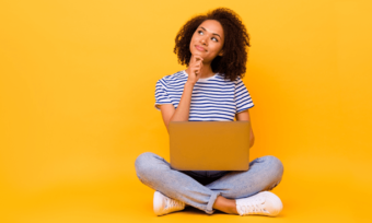 Woman using laptop with yellow background, Internet contention ratio concept.