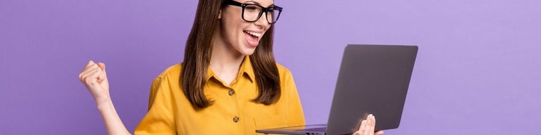 A woman looking at a laptop excitedly