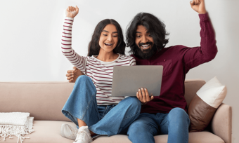 Young couple using laptop and celebrating. Refer a friend internet