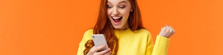 A person looking at a phone excitedly