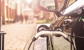 Black electric vehicle charging on the street