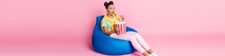 Woman watching TV while eating popcorn