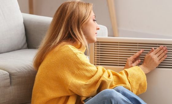 Lady getting warm in front of heater