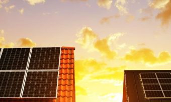 Solar on rooftops with rising sun in the background.