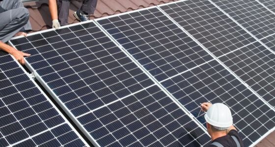 two men on a roof with solar panels