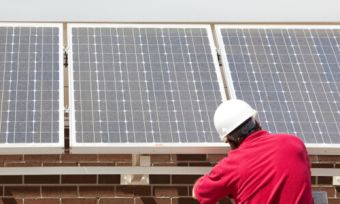 people adjusting solar panels