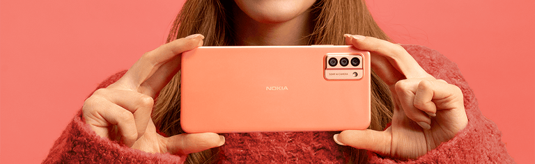 Close-up of woman in holding peach Nokia smartphone