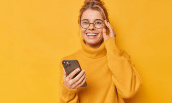 Happy woman with 4G phone and yellow background