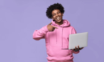 Happy man in pink hoodie using laptop