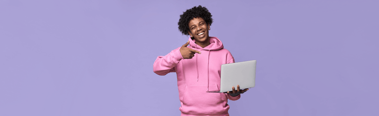 Happy man in pink hoodie using laptop