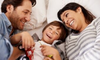 Mother and father and young child laughing and playing with toys