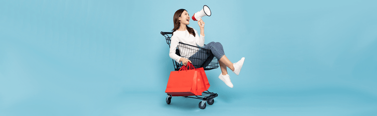 Black Friday sale - woman with shopping bag in trolley and megaphone