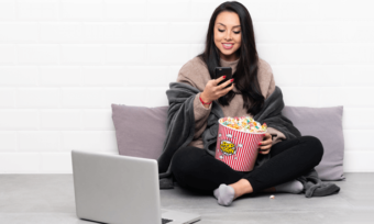 Best streaming bundles in Australia - woman using phone and watching streaming on laptop