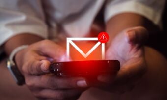 Person holding phone with envelope and warning sign icons