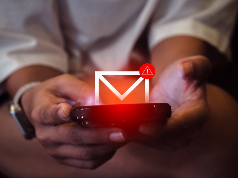 Person holding phone with envelope and warning sign icons